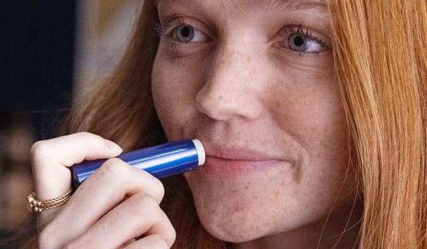 woman using Aquaphor Lip Repair