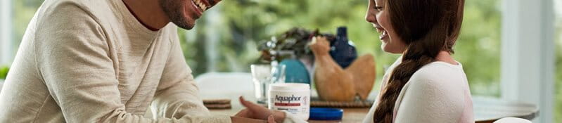 Young girl helping her dad apply hand cream.