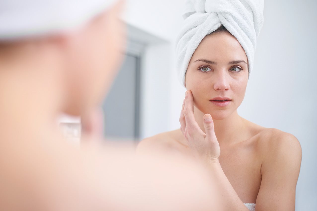 Frau sieht in den Spiegel