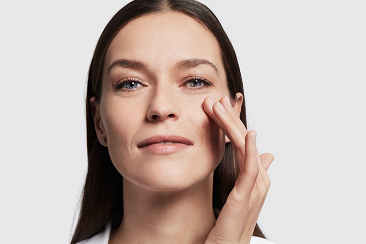 Frau greift mit Hand ins Gesichts