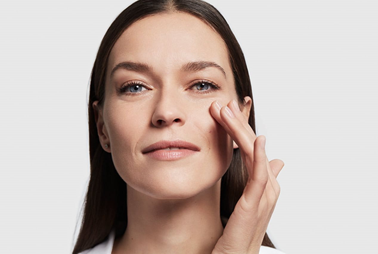 Frau greift mit Hand ins Gesichts