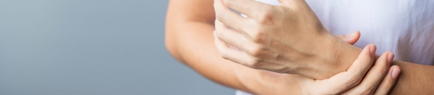 Frau greift an ihr Handgelenk