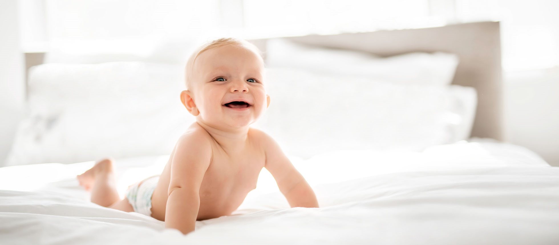 Baby in Windel auf Bett