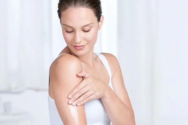 Vrouw brengt body lotion aan voor de gevoelige huid
