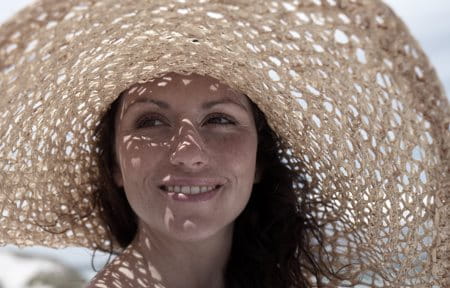 Frau mit großem Hut als Sonnenschutz