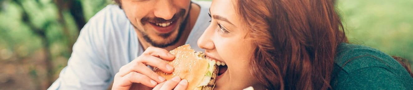 Frau teilt sich einen Burger mit einem Mann