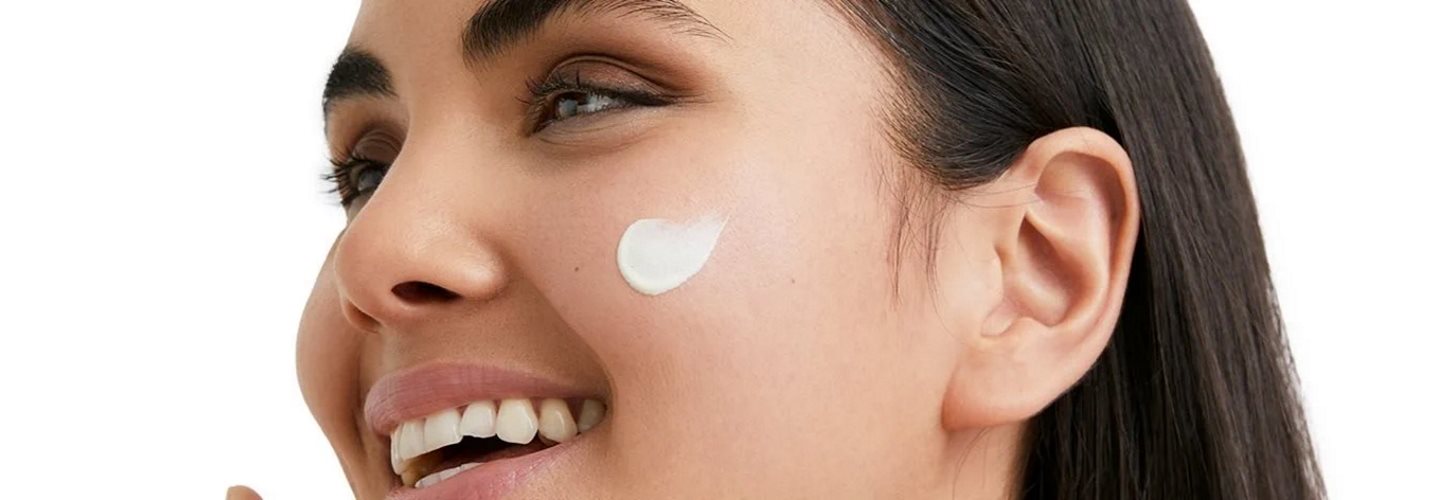 Frau mit Creme auf dem Gesicht