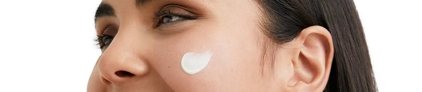 Frau mit Creme auf dem Gesicht