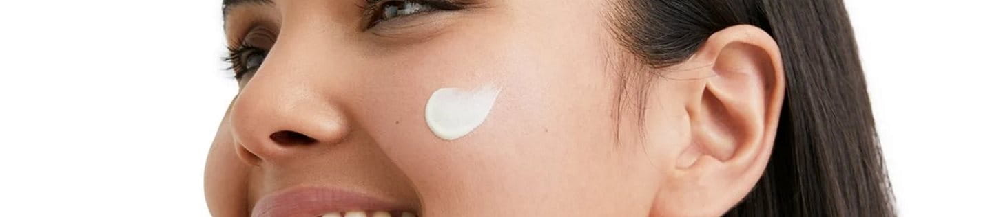 Frau mit Creme auf dem Gesicht