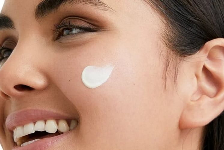 Frau mit Creme auf dem Gesicht