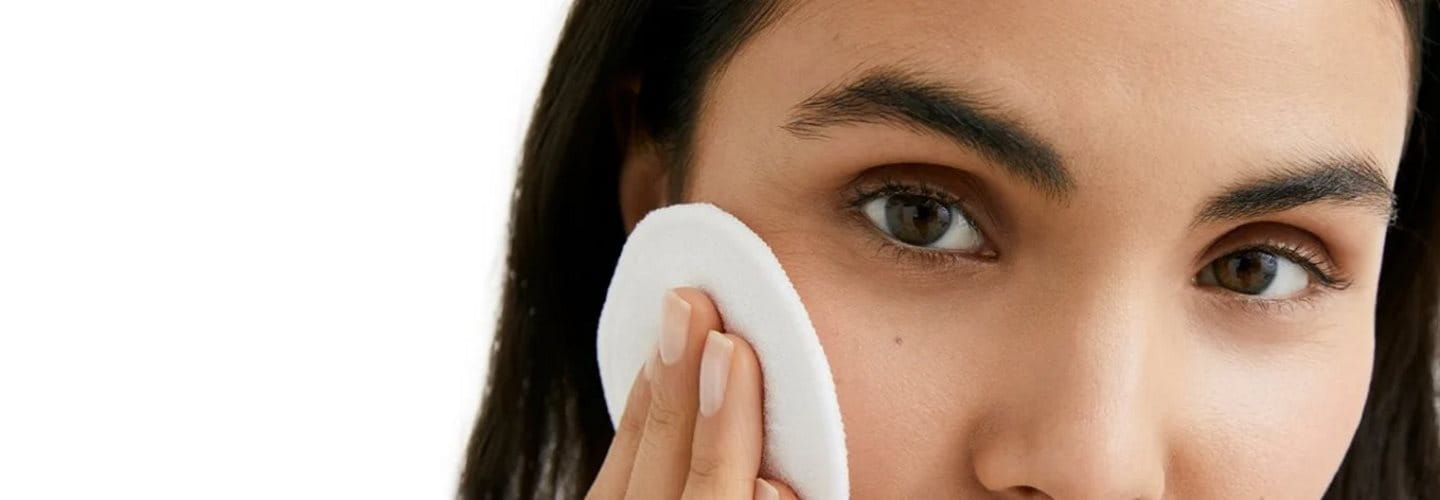 Frau benutzt Wattepad im Gesicht