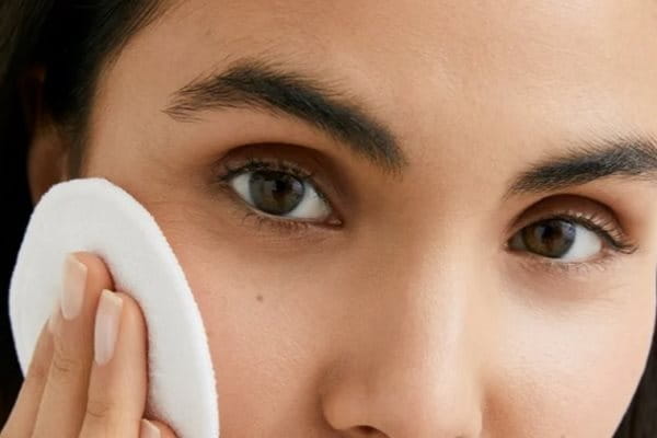 Frau schminkt sich ab mit Wattepad.