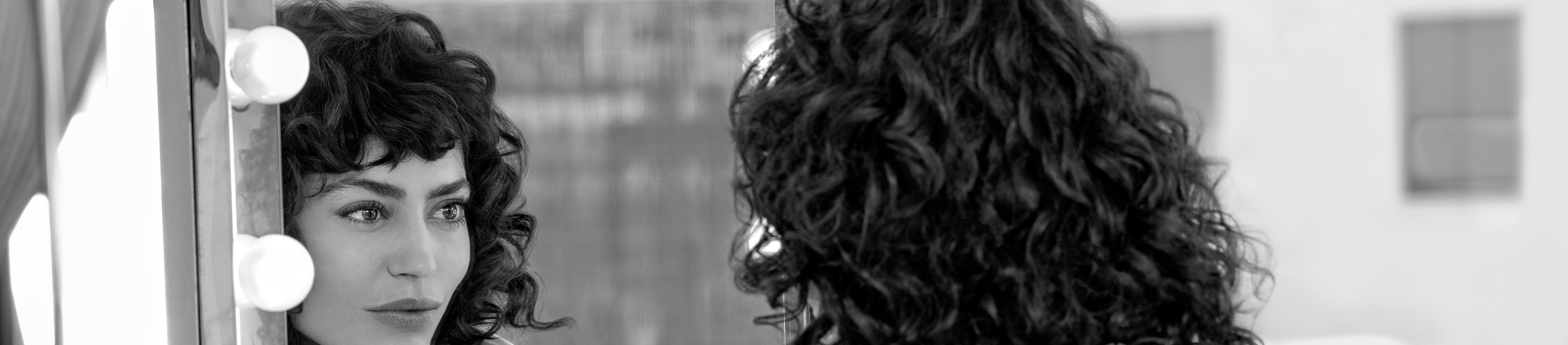 Woman looking at her own reflection in mirror