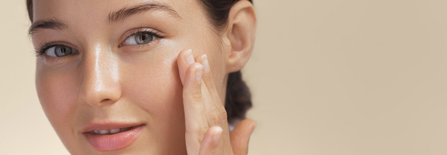 Kobieta z ładną cerą dotykająca twarzy