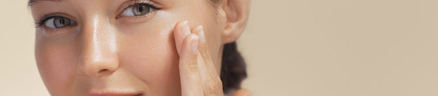 Kobieta z ładną cerą dotykająca twarzy