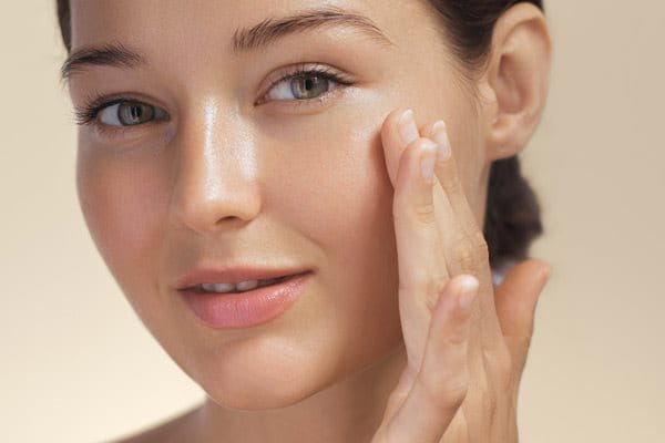 Kobieta z ładną cerą dotykająca twarzy