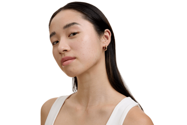 Kvinna med svart hår mot en vit bakgrund