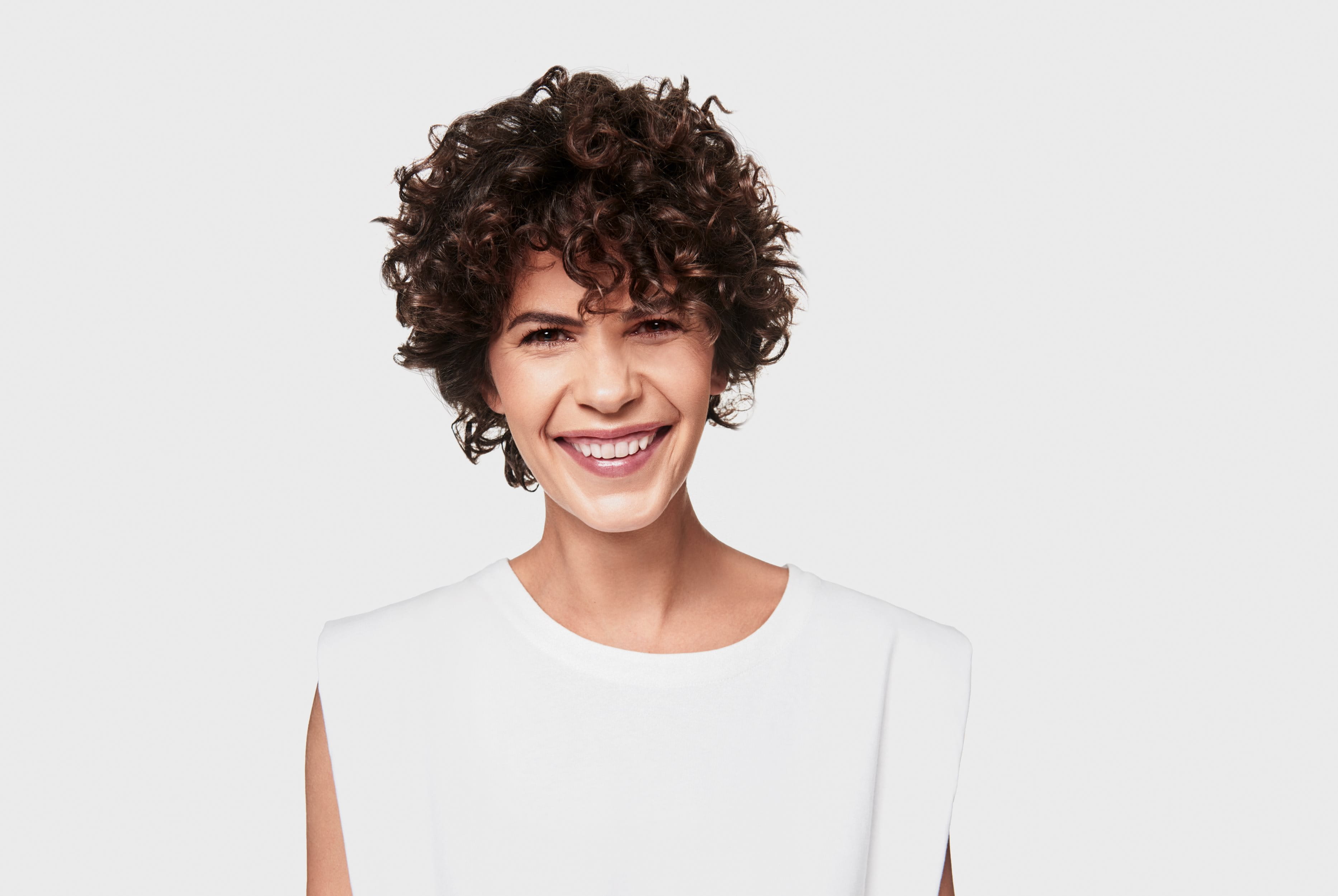 leende kvinna mot grå bakgrund