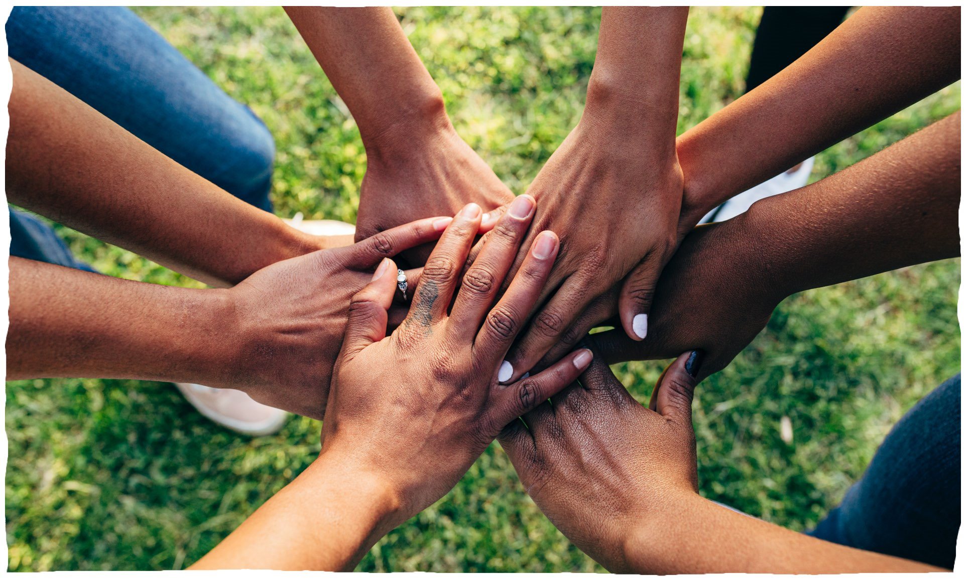 Menschen, die sich im Kreis die Hände reichen, als Symbol für Teamarbeit.