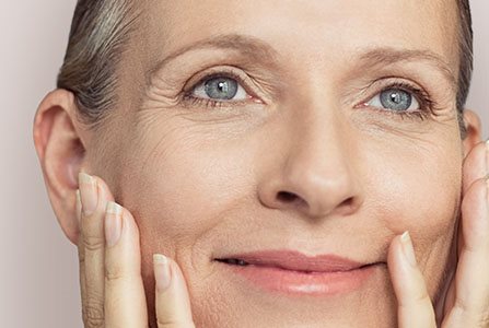 Mujer observando su piel envejecida