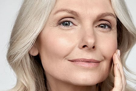 Mujer mayor tocándola a la cara