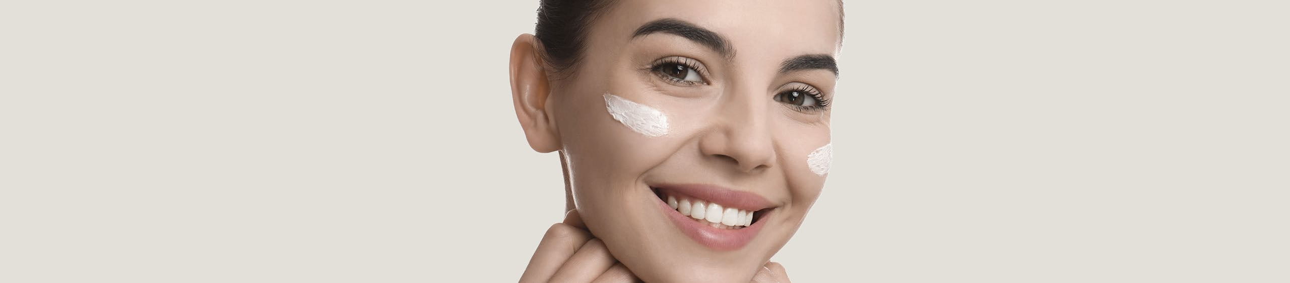 Mujer sonriente con cremas en la cara