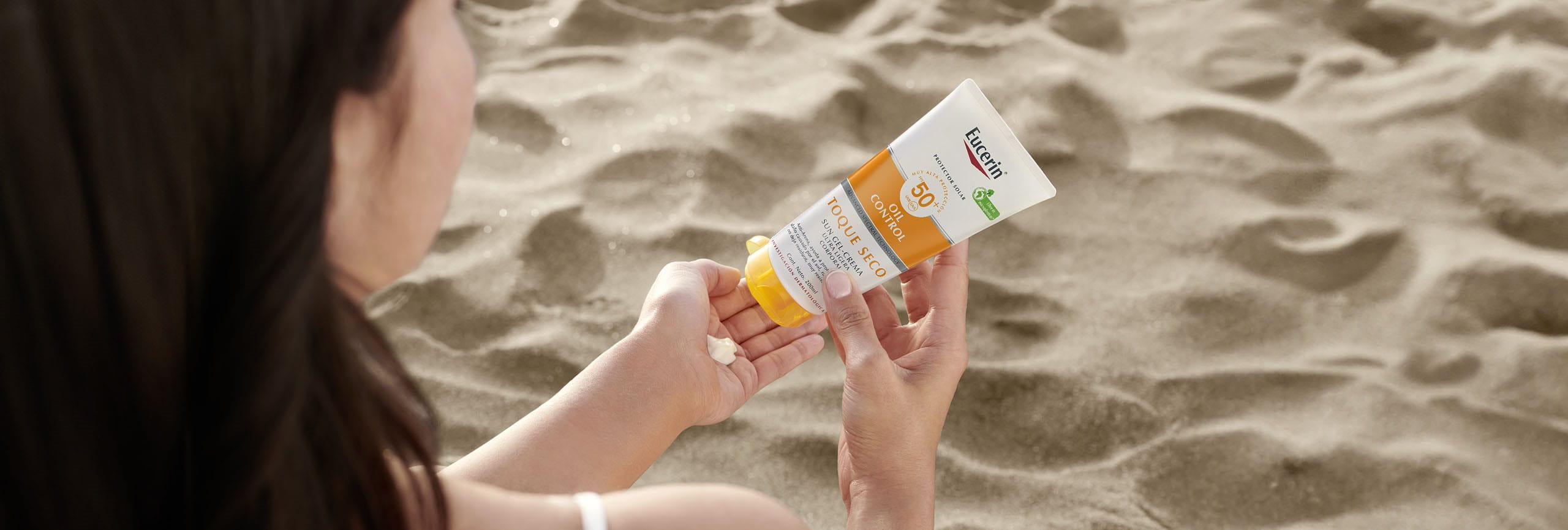 Persona aplicando protección solar para cara y cuerpo