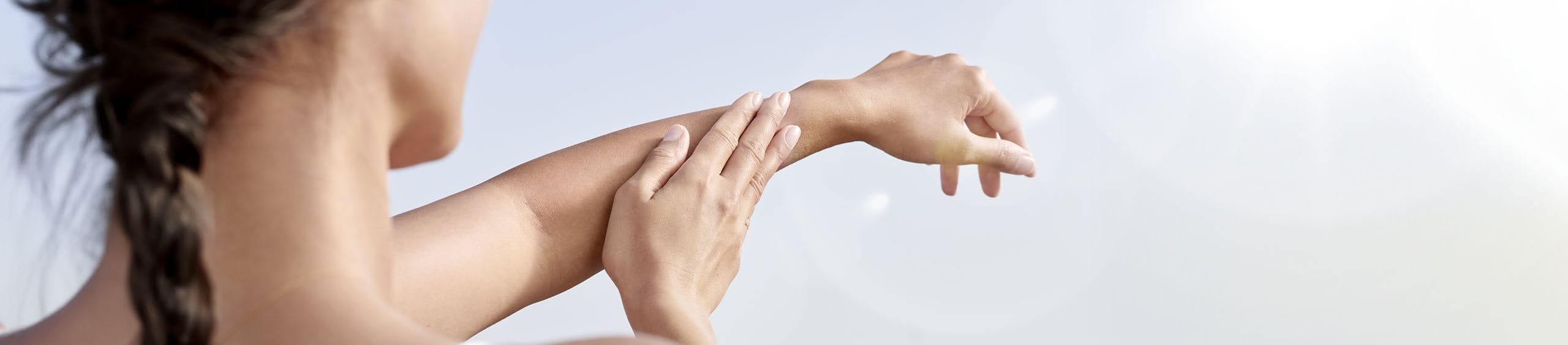 Mujer cuidando su piel de los efectos de los rayos UV en la piel