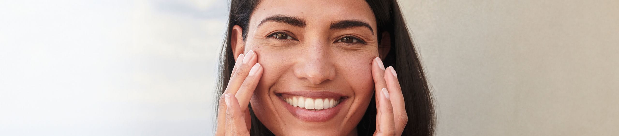 Mujer colocando protector solar encima de maquillaje