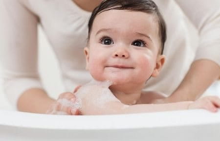 Baby in bad die wordt gewassen