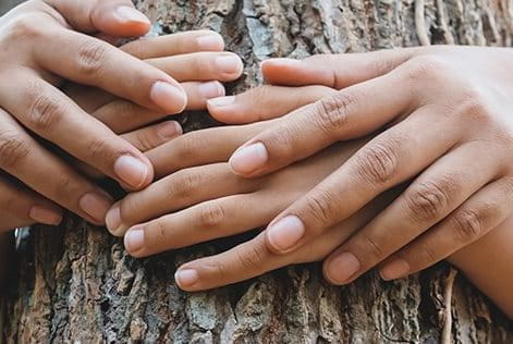 Deux personnes faisant un câlin à un arbre.