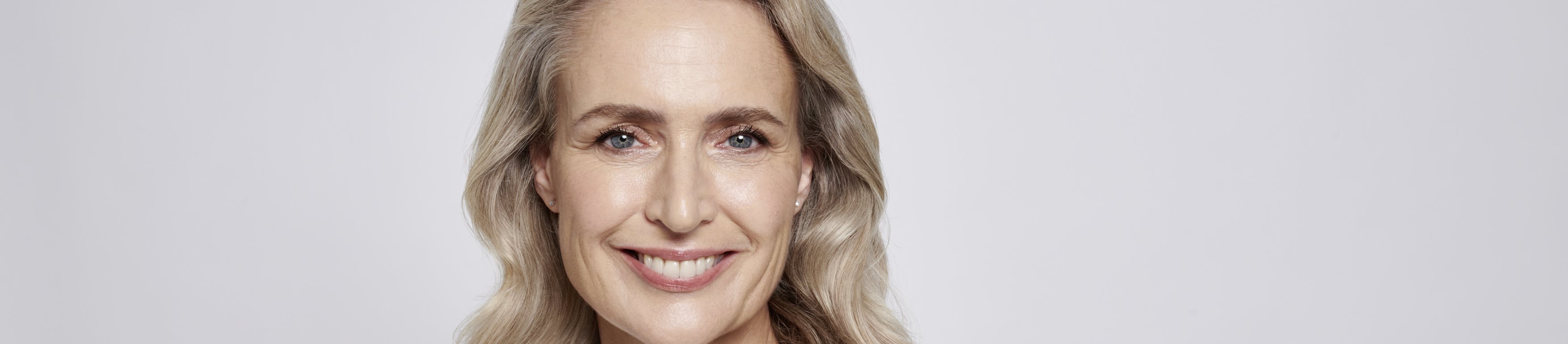 Une femme plus âgée appliquant de la crème sur son visage