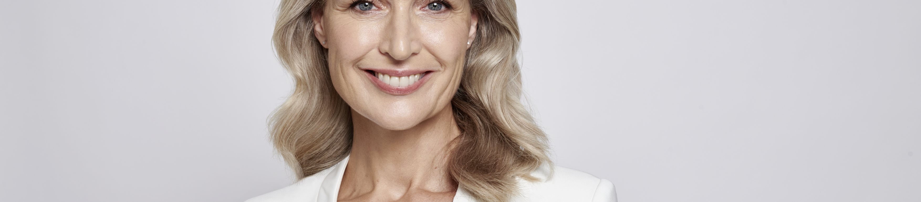 Een oudere vrouw die crème op haar gezicht aanbrengt