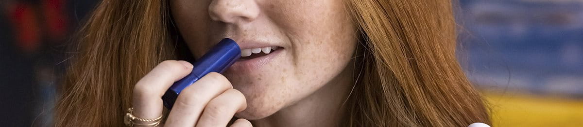 Woman using aquaphor lip products