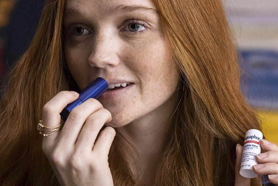 woman using aquaphor lip products