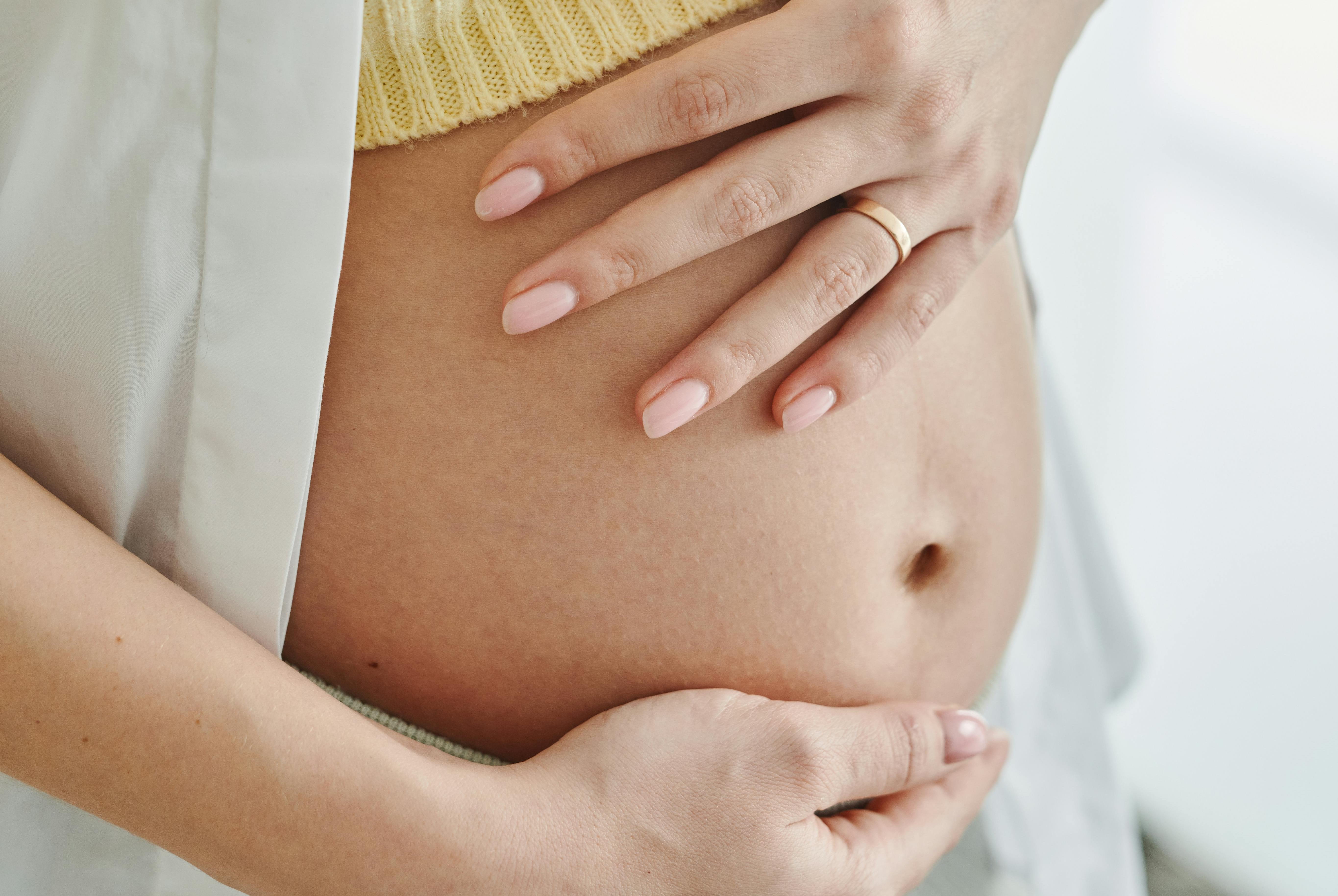 a pregnant woman holding her belly