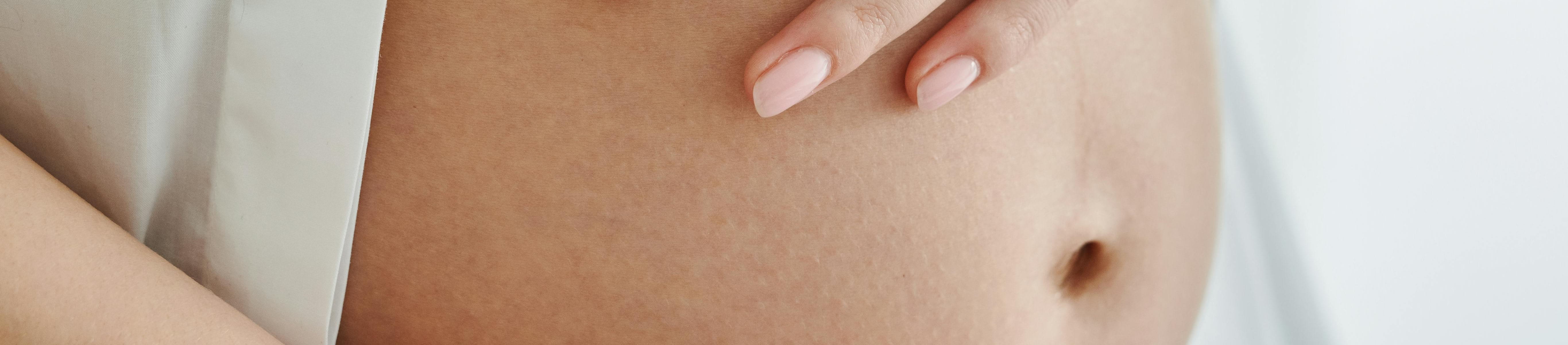 en gravid kvinna som håller om sin mage