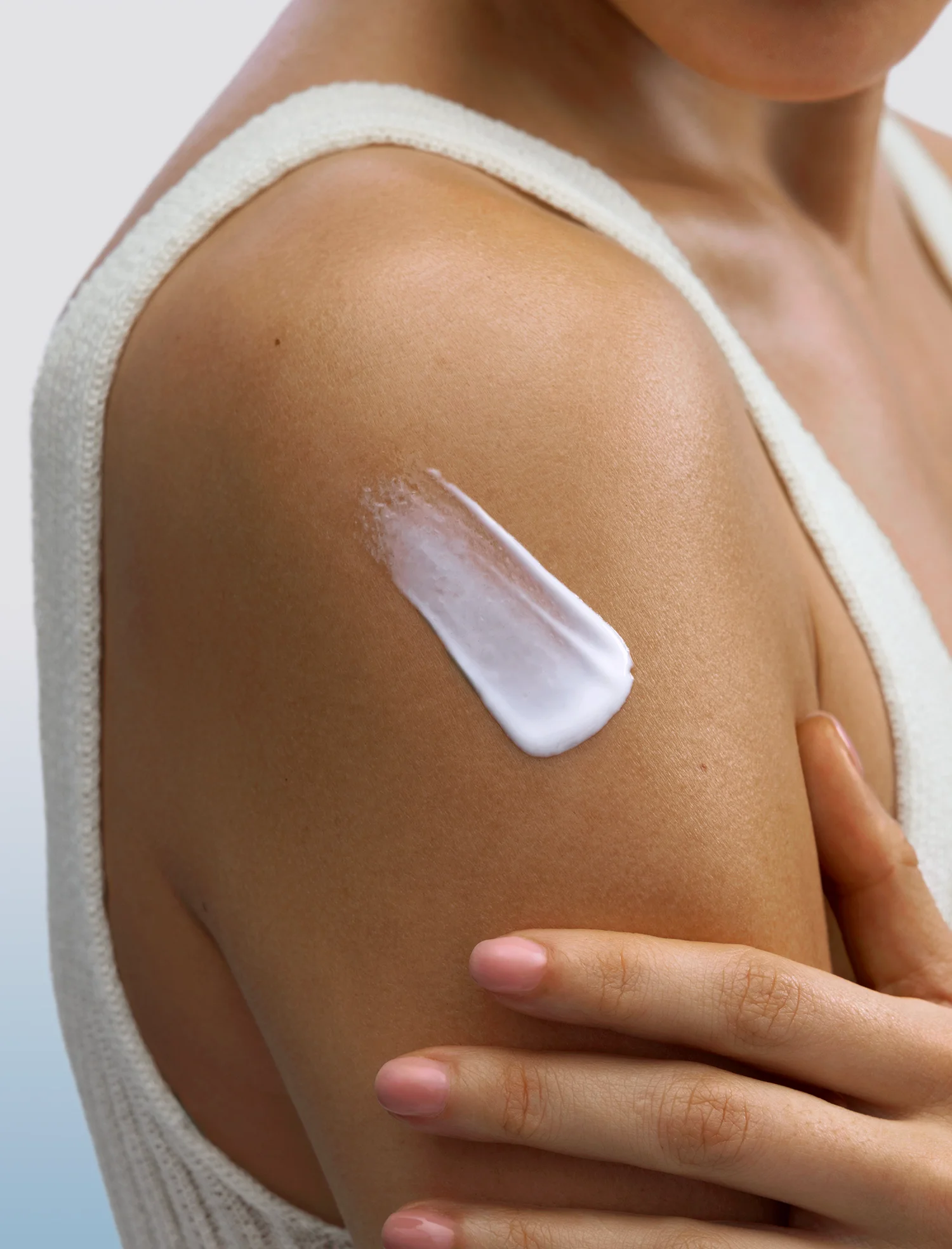 image of a person applying body cream to their shoulder