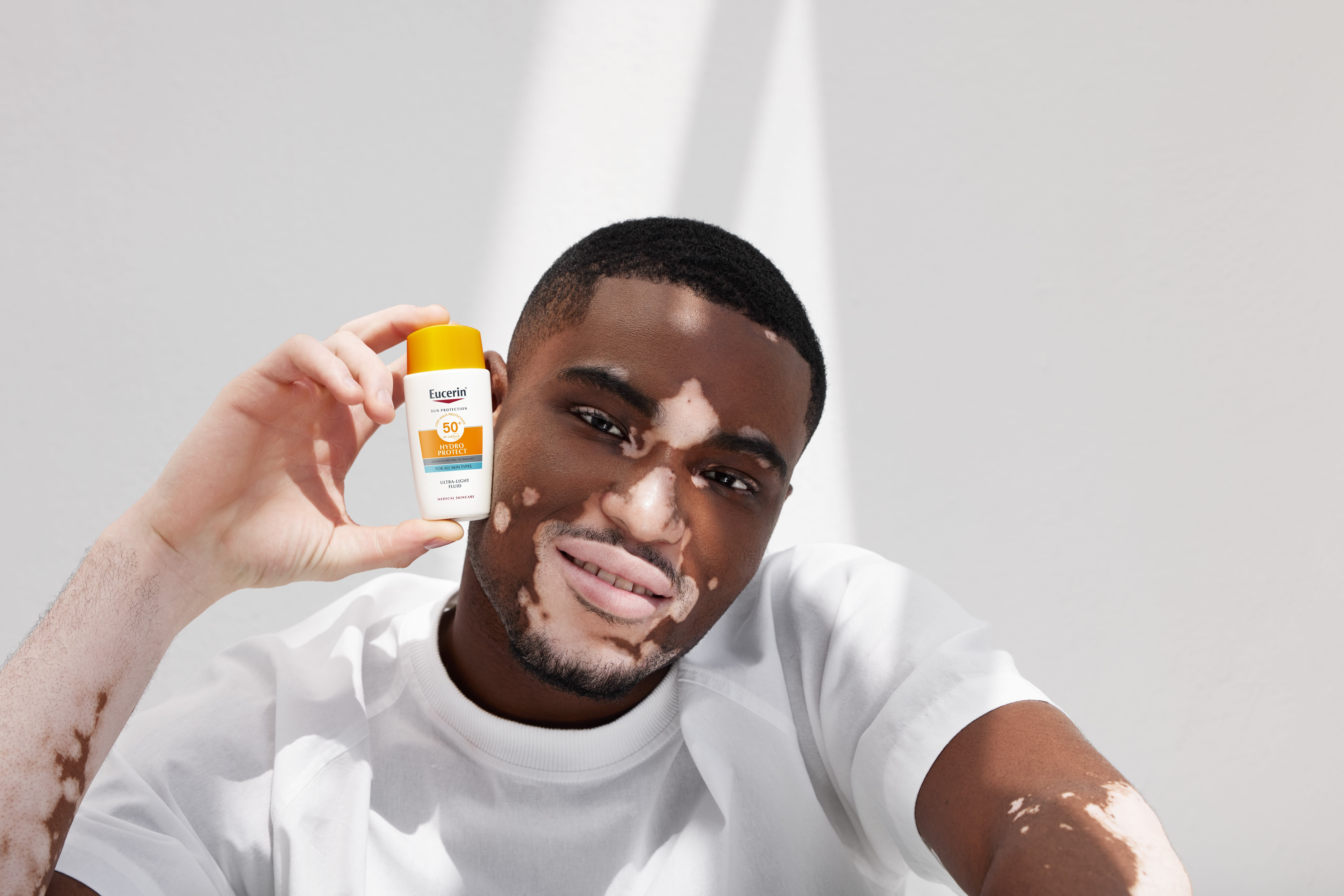 image of a man holding sunscreen in the sun