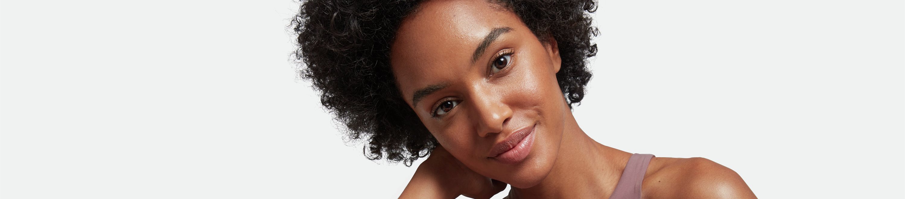 Woman posing with a skincare product.