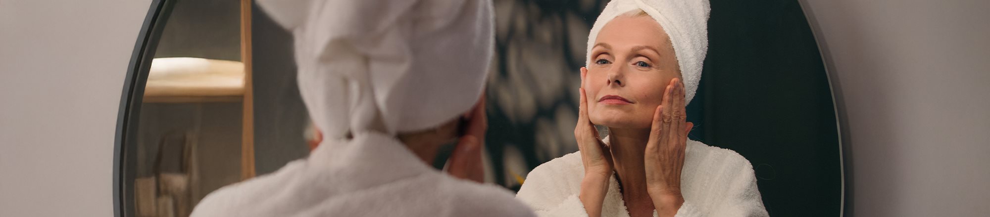 Frau betrachtet sich im Spiegel