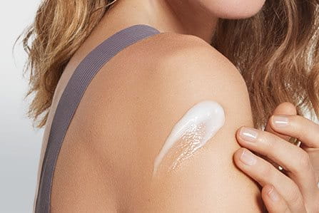 Persona hidratando y cuidando su piel corporal