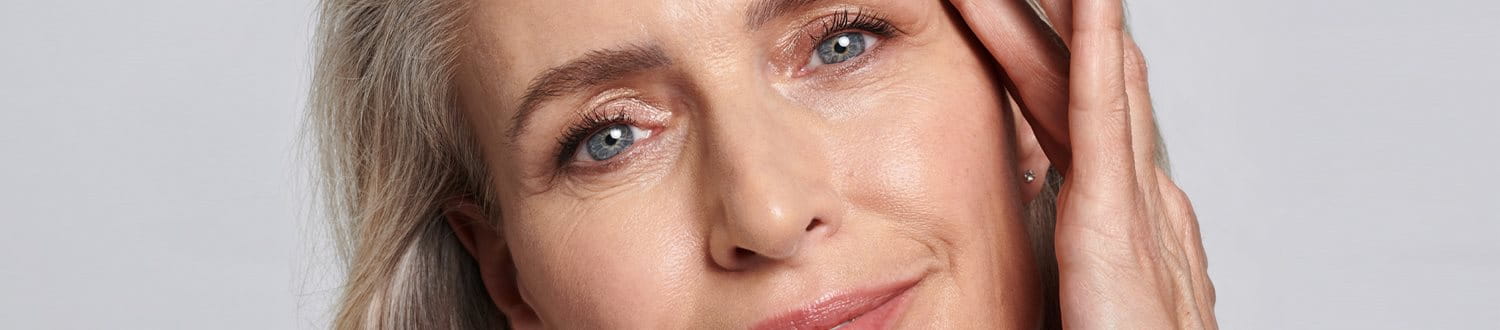 kvinna som ler mot en grå bakgrund