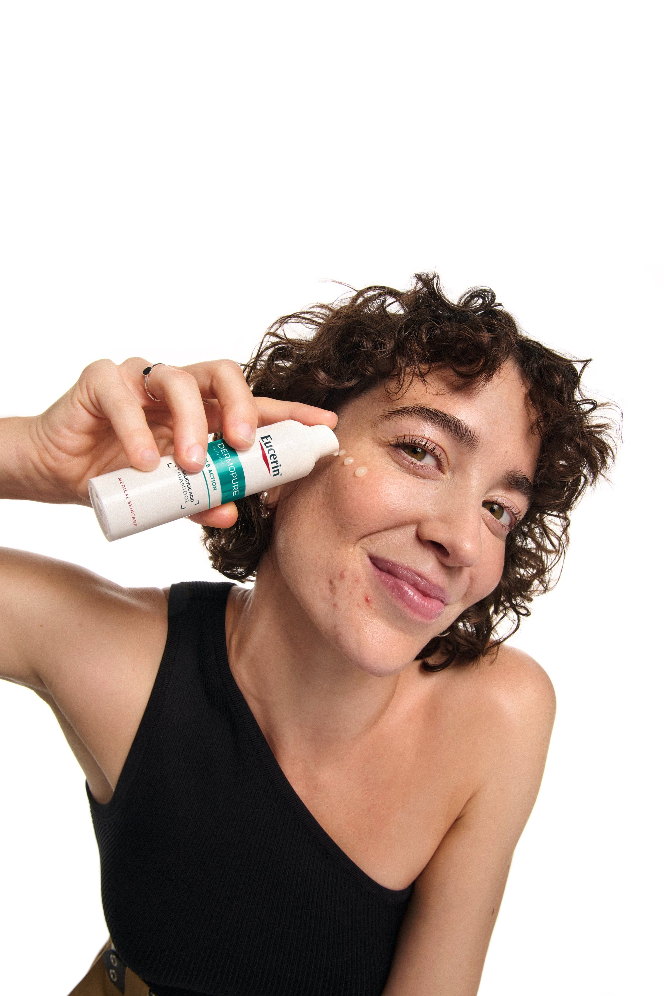 A woman using Eucerin Triple Action Serum
