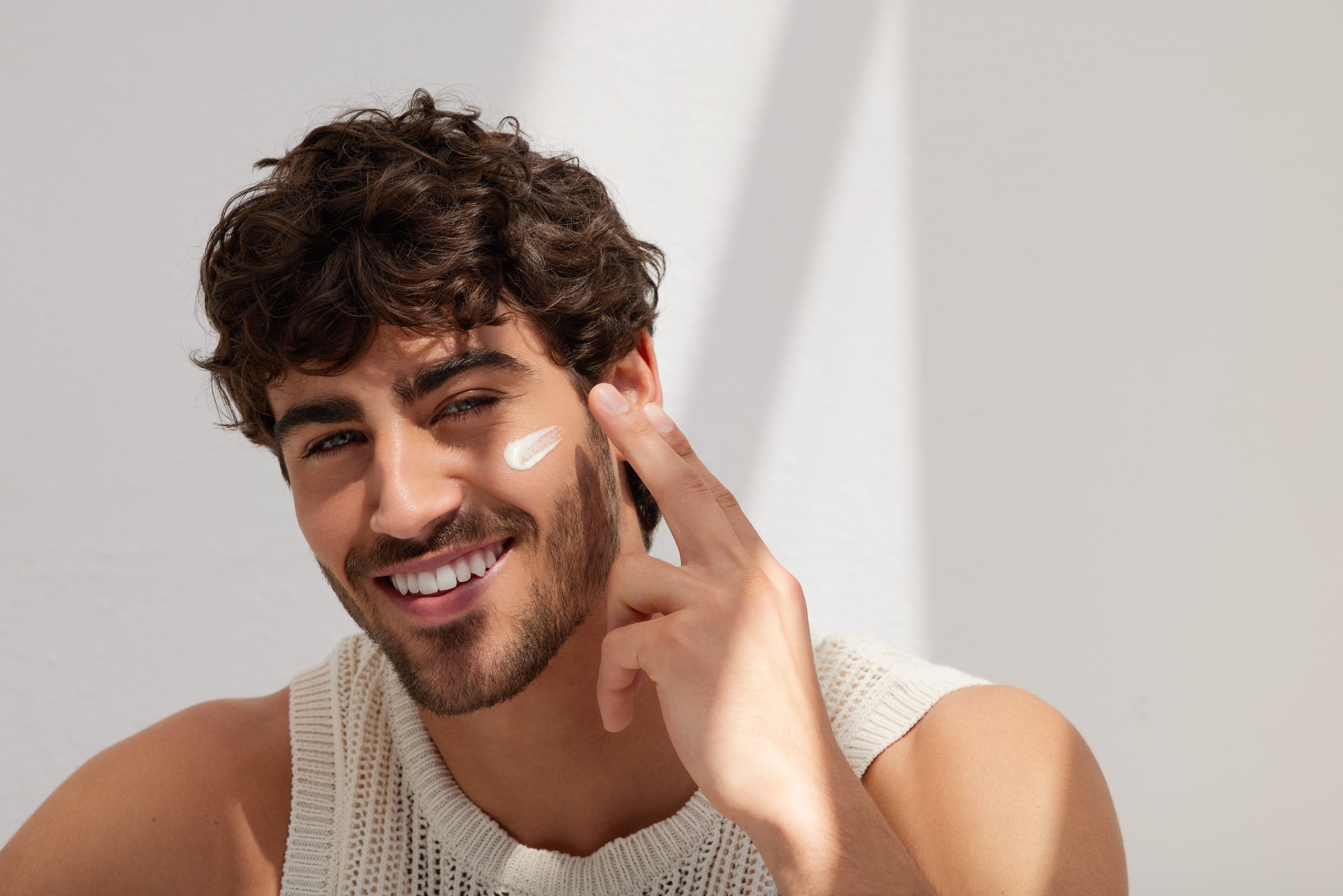 Man applying one of the above optional steps, eye cream, face mask or exfoliator