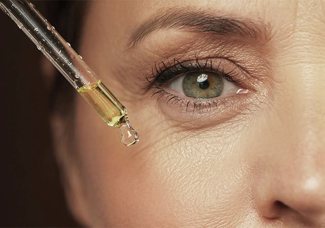 foto di donna che applica siero al retinolo nel contorno occhi