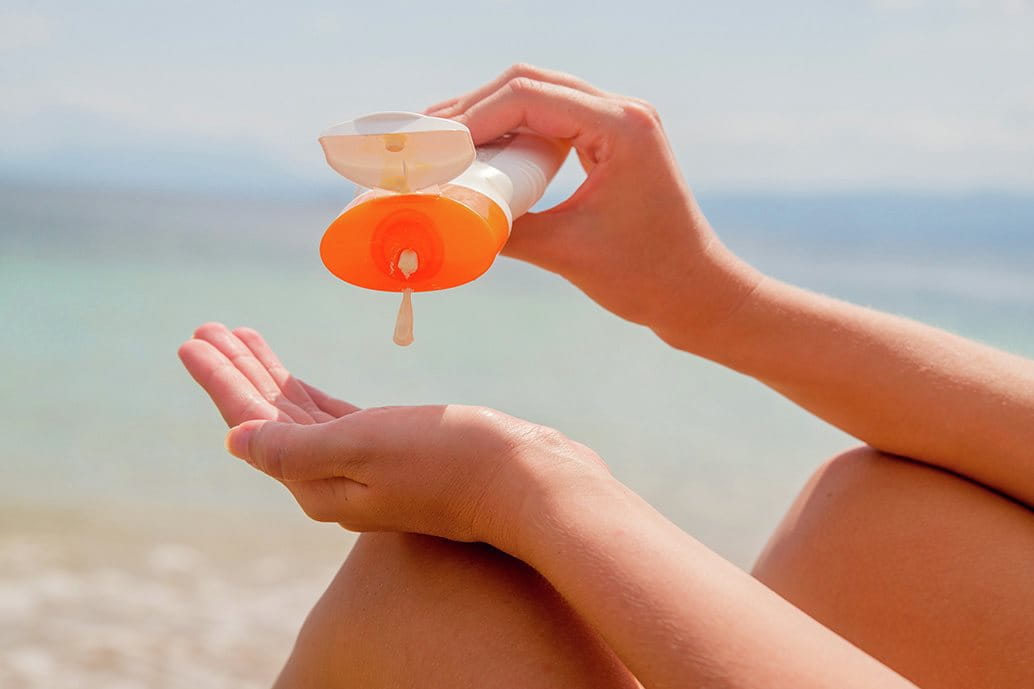 ragazza che si mette la crema solare