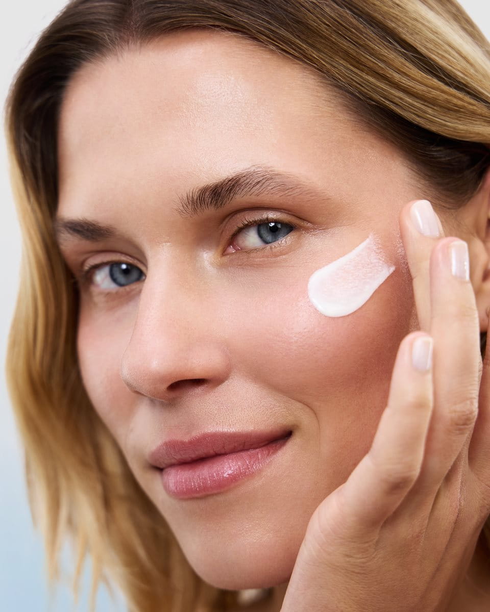 woman applying sunscreen to face