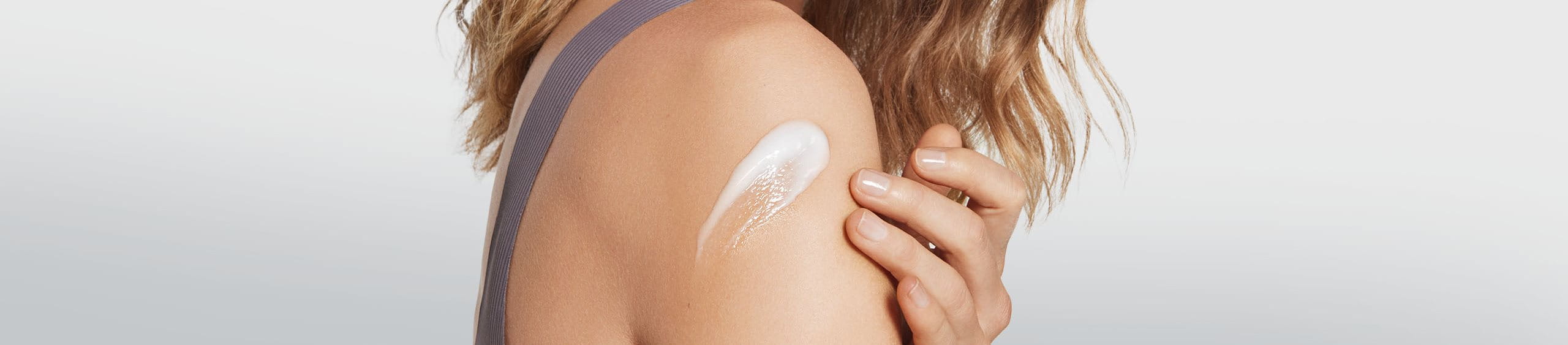 Persona hidratando y cuidando su piel corporal