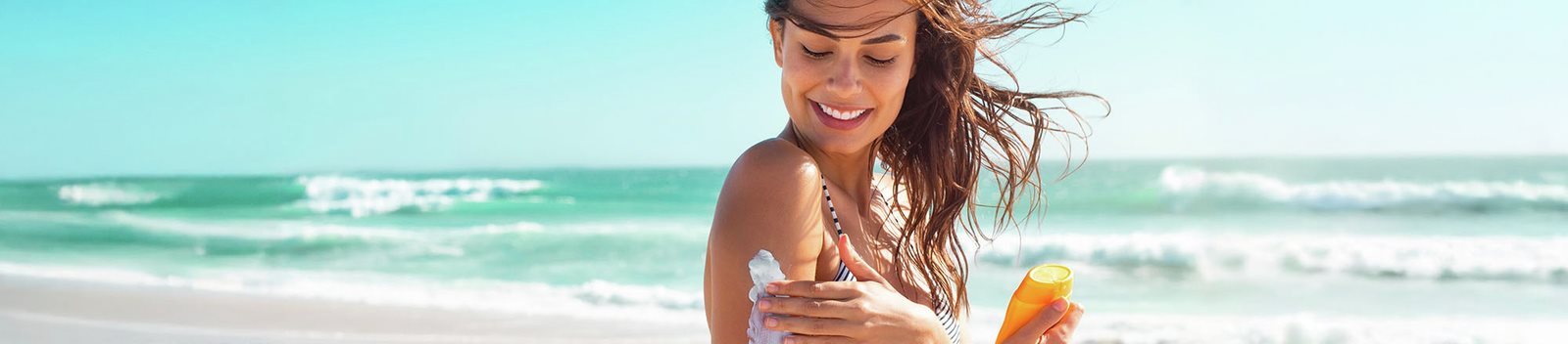 Apllicazione della crema solare sotto il sole